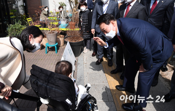 윤석열 대통령 당선인이 16일 오후 서울 종로구 통의동에 위치한 한 식당에서 점심 식사를 마친 후 참모진들과 함께 산책을 하며 어린이와 인사를 하고 있다. [사진=김성진 기자]