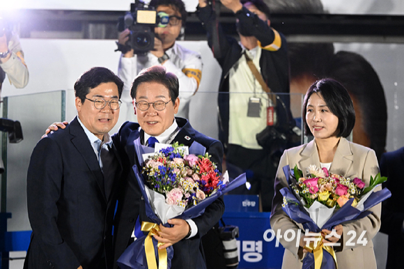 당선이 확실시된 이재명 더불어민주당 대통령 후보와 김혜경 여사가 4일 오전 서울 여의도 국회 앞에서 열린 국민 개표방송 행사에서 지지자들의 환호에 손을 들어 화답하고 있다. [사진=곽영래 기자]