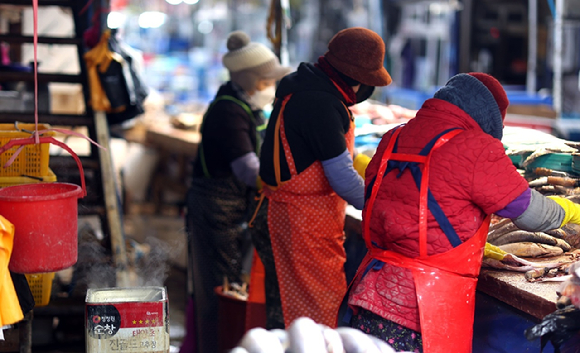 추위가 이어진 가운데 경남 창원시 마산합포구 마산어시장에서 상인들이 피어오르는 김 곁에서 분주하게 생선을 손질하고 있다. [사진=연합뉴스]