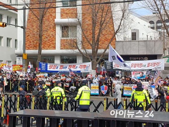 윤석열 대통령 지지자들이 지난 13일 서울 종로구 헌법재판소 앞에서 시위하는 모습. 그 뒤로는 '양심과 법이면 탄핵은 각하다'라는 문구가 적힌 현수막이 걸려 있다. [사진=라창현 기자]