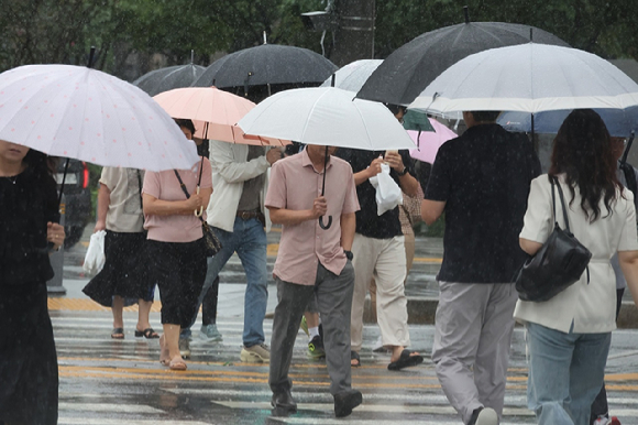 서울 종로구 광화문광장 인근에서 우산을 쓴 시민들이 발걸음을 재촉하고 있다. [사진=연합뉴스]