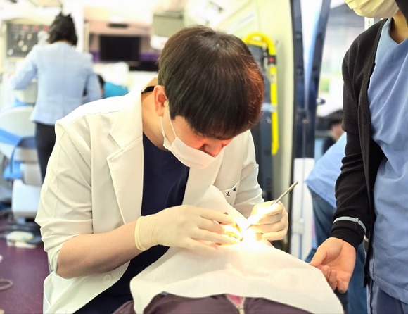 고건영 원주 유디치과의원 대표원장이 원주보훈요양원 어르신을 대상으로 구강검진을 하고 있다. [사진=유디치과]