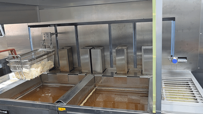 관절형 로봇이 움직이며 치킨을 조리하고 있다. [사진=구서윤 기자]