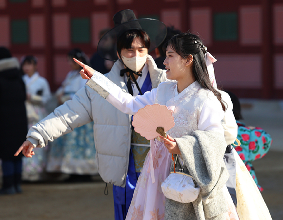 서울 낮기온이 오르면서 포근한 초봄 날씨를 보인 26일 서울 경복궁을 찾은 관광객이 외투를 손에 걸친 채 궁궐을 돌아보고 있다. [사진=연합뉴스]