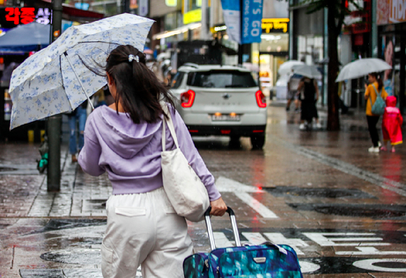 서울 전역에 호우주의보가 내려진 지난 23일 오전 우산을 쓴 시민들이 거리를 이동하고 있다. [사진=뉴시스]