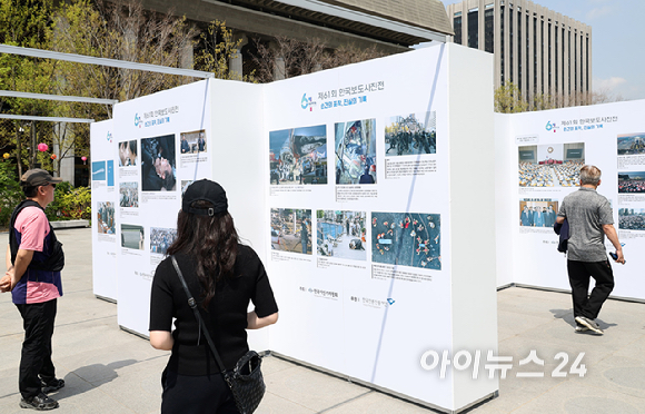 21일 서울 종로구 광화문 광장에서 열린 제61회 한국보도사진전 '순간의 포착, 진실의 기록' 개막식에서 참석자들이 개막을 알리는 커팅식을 하고 있다. 왼쪽부터 유인촌 문화체육관광부 장관, 권영세 국민의힘 비상대책위원장, 이호재 한국사진기자협회장, 우원식 국회의장, 박찬대 더불어민주당 대표 직무대행 겸 원내대표, 오세훈 서울시장. [사진=사진공동취재단]