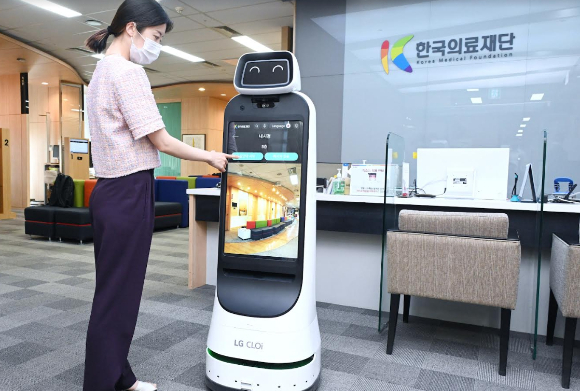 한국의료재단 종합검진센터 직원이 LG 클로이 가이드봇을 활용해 건강검진 안내를 받는 모습을 시연하고 있다. [사진=LG전자 ]