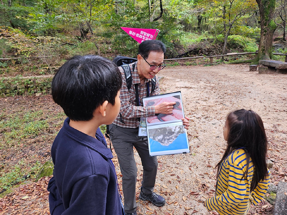 장석규 종로구청 숲길체험지도사가 19일 서울 종로구 부암동 백사실 계곡에서 진행된 '스타 고우리와 함께 하는 제10회 희망찾기 등산·트레킹 교실'에서 참가 어린이들에게 친절한 설명을 해주고 있다. [사진=이미영]