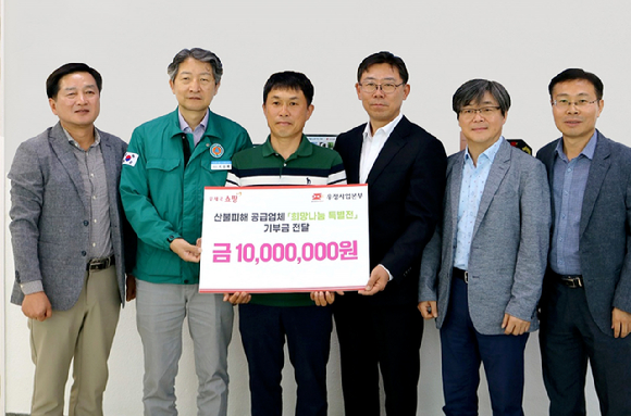노기섭 우정사업본부 경북지방우정청장(오른쪽 세 번째)이 지난 23일 청송우체국을 방문해 희망나눔 특별전을 통해 마련한 수익금 1000만 원을 기부하고 있다. [사진=우정사업본부]