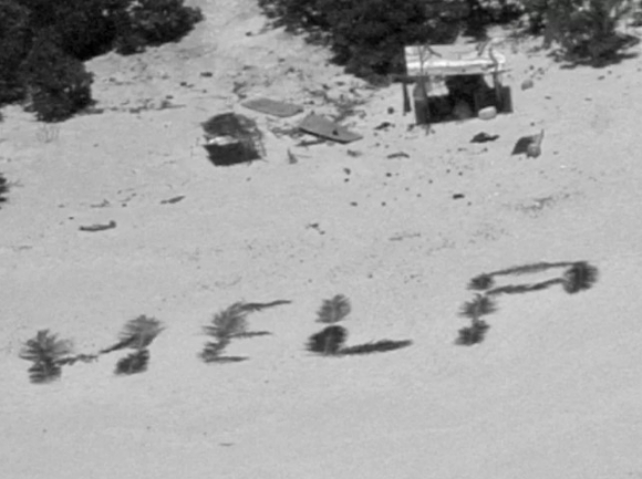 태평양 피켈럿 환초의 모래밭에 야자잎으로 '도와달라(HELP)' 라는 글씨가 쓰여 있다. [사진=미국해안경비대]
