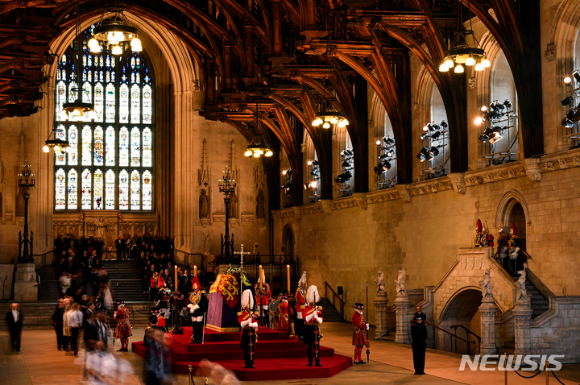 14일(현지시간) 영국 런던 웨스트민스터 홀에서 일반인들이 고 엘리자베스 2세 여왕 관을 향해 경의를 표하고 있다. 일반인들의 조문은 오는 19일 엄수되는 국장 전까지 허용된다. [사진=런던=AP/뉴시스]