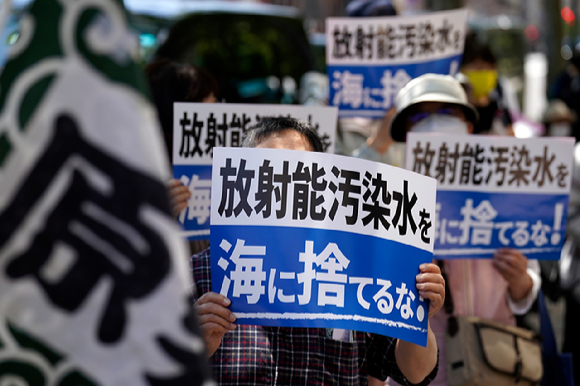 지난 5월 16일 일본 도쿄에 있는 도쿄전력(TEPCO) 본사 앞에서 시위대가 '방사능 오염수 방류 반대' 손팻말을 들고 후쿠시마 오염수 방류에 반대하고 있다. 이날 수십 명의 반핵운동가가 쓰나미로 파괴된 후쿠시마 원자력 발전소를 운영하는 도쿄전력 밖에 모여 방사능 오염수 방류 계획 철회를 요구했다 [사진=뉴시스]