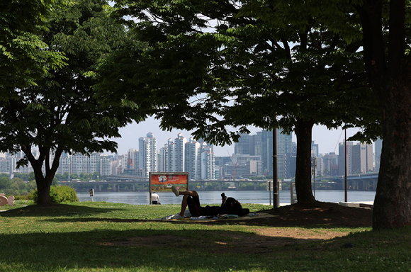 서울 영등포구 여의도한강공원을 찾은 한 시민이 나무그늘에서 휴식을 취하고 있다. [사진=뉴시스]