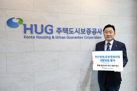 최인호 주택도시보증공사(HUG) 사장이 13일 '민간참여 공공주택사업 금융보증' 도입을 알리는 안내판을 들고 기념 촬영을 하고 있다 [사진=주택도시보증공사(HUG) 제공]