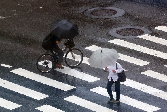 서울 을지로입구역 인근에서 시민들이 우산을 쓰고 길을 건너고 있다. [사진=연합뉴스]