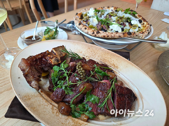 올리페페 강남점 내부. 한쪽 벽면에는 와인이 진열돼 있고, 매장 중앙에는 대형 피자 화덕이 자리하고 있다. [사진=구서윤 기자]
