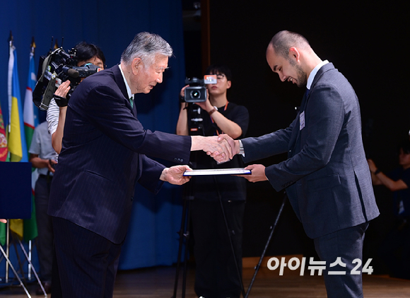 이중근 부영그룹 회장 겸 우정교육문화재단 이사장이 26일 서울 중구 대한상공회의소 국제회의장에서 열린 '2026년 제2학기 장학금 수여식'에 참석해 장학생 대표 카자흐스탄 아이가늠 자리너바와 인사를 나누고 있다. [사진=정소희 기자]