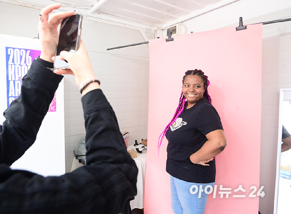 10일 서울 여의도 한강공원에서 열린 '2026 서울 스프링 페스티벌' 케이팝아케이드 부스에서 외국인 관광객이 포토카드 만들기 체험을 하고 있다. [사진=정소희 기자]