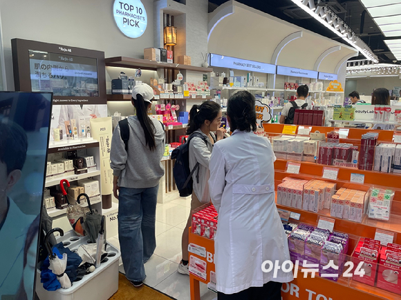 20일 서울 중구 명동의 한 마트형 약국에서 외국인 관광객이 약사에게 제품 설명을 듣고 있다. [사진=정승필 기자]