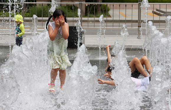 서울 종로구 광화문 광장을 찾은 아이들이 바닥 분수대에서 물놀이를 하며 휴일을 보내고 있다. [사진=뉴시스]