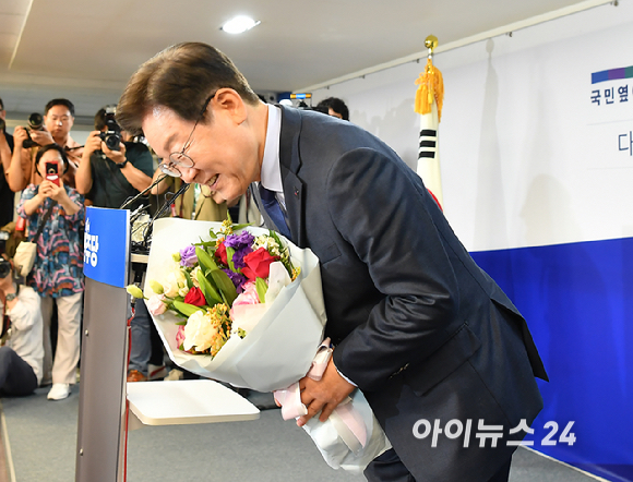 이재명 전 더불어민주당 대표가 10일 오전 서울 여의도 더불어민주당 중앙당사에 당 대표 출마 기자회견에서 지지자에게 꽃다발을 받고 있다.