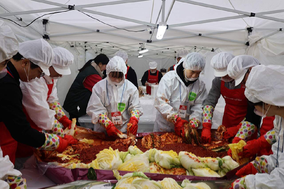 지난 19일 서울 송파구 문정노인종합복지관에서 열린 사랑의 김장 나눔 행사에서 롯데마트 임직원들이 취약계층에 전달할 김장 김치를 담그고 있다. [사진=롯데마트]