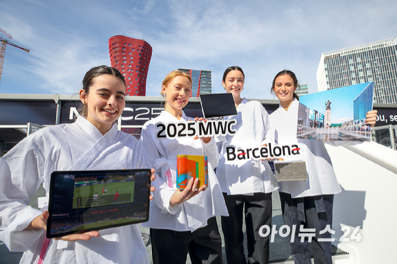 세계 최대 이동통신 전시회 '모바일 월드 콩그레스(MWC) 2025' 개막을 이틀 앞둔 1일(현지시간) 스페인 바르셀로나 에스파냐 광장 쌍둥이 탑 앞에서 KT 모델들이 AI 실시간 번역기술이 적용된 K-스타디움, 테이블 오더 서비스 KT 하이오더, AI 기술이 적용된 스마트 홈 환경 등을 홍보하고 있다. [사진=사진공동취재단]