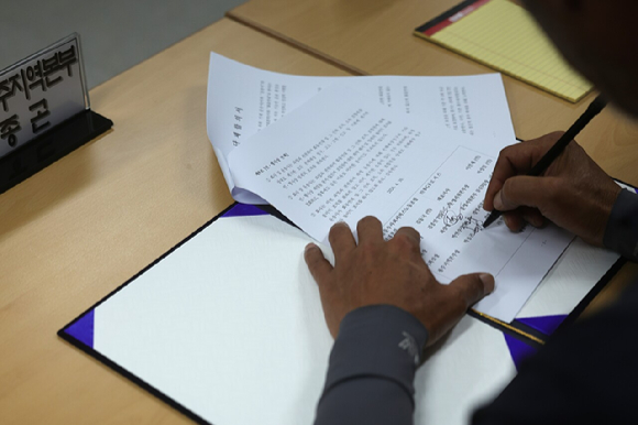 민주노총 화물연대와 BGF로지스가 30일 오전 경남 진주시 고용노동부 진주지청에서 단체합의서 조인식을 했다. 사진은 이민재 BGF로지스 대표이사(왼쪽)와 김동국 화물연대 위원장이 기념 촬영을 하는 모습. [사진=연합뉴스]