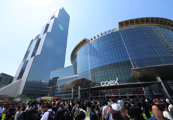 25일 서울 강남구 코엑스 내 입점한 식당에서 화재가 발생해 관람객 등 시민들이 건물 밖으로 대피해 있다. [사진=연합뉴스]