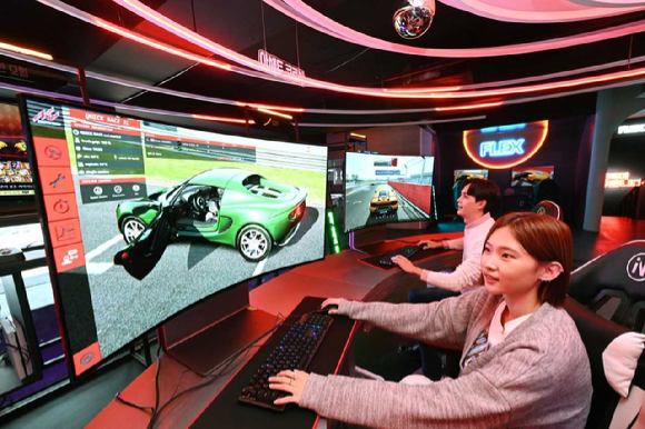 LG전자 모델들이 시청환경에 맞춰 자유롭게 화면을 구부렸다 펼 수 있는 LG 올레드 플렉스로 게임을 즐기고 있는 모습. [사진=LG전자]