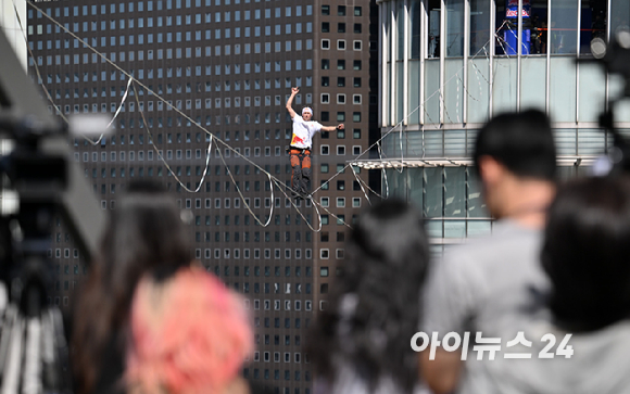 세계적인 슬랙라인 선수 얀 루스(Jaan Roose)가 1일 서울 광화문 사거리 상공 120m 높이에서 '레드불 서울 줄타기' 퍼포먼스를 선보이고 있다. [사진=정소희 기자]
