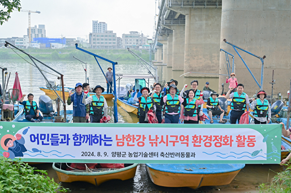  전진선 군수가 남한강 낚시구역 환경정화 활동을 마치고 기념촬영을 하고 있다. [사진=양평군]