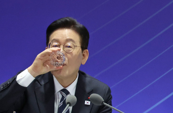 이재명 대통령이 지난 23일 울산전시컨벤션센터에서 열린 '울산의 마음을 듣다' 타운홀미팅 간담회에서 물을 마시고 있다. [사진=연합뉴스]