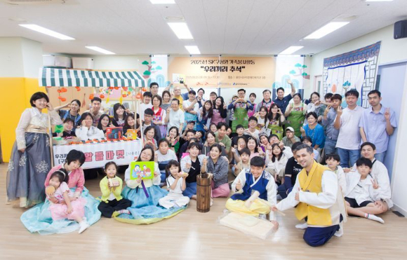 SK케미칼 임직원들이 지난 20일 경기 용인시수지장애인복지관에서 발달장애인들과 구성원 가족이 함께하는 '우리끼리 추석'에서 송편 만들기와 전통놀이 체험을 마치고 기념 촬영을 하고 있다. [사진=SK케미칼]