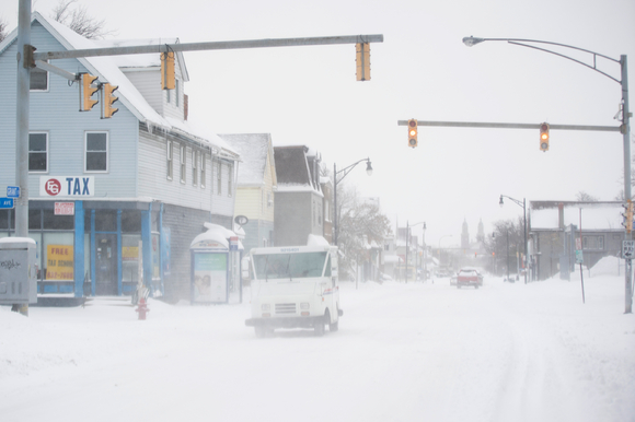 19일(현지시간) 미국 뉴욕주 버팔로 그랜트 스트리트에서 우편차가 눈으로 뒤덮인 도로를 지나가고 있다. 뉴욕주에서는 180㎝가 넘는 눈이 내렸으며 3명이 사망했다. [사진=뉴시스]