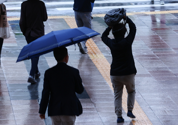  지난 24일 서울 용산역 인근에서 시민들이 우산을 쓰고 출근길에 나서고 있다. [사진=뉴시스]