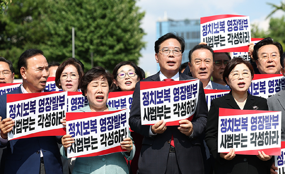 국민의힘 송언석 비상대책위원장 겸 원내대표를 포함한 의원들이 18일 서울 서초구 서울중앙지방법원 앞에서 열린 현장비상의원총회에서 구호를 외치고 있다. [사진=연합뉴스]