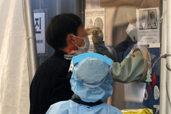 서울 용산역 전면광장에 설치된 임시선별진료소에서 의료진이 검체를 채취하고 있다. [사진=뉴시스]