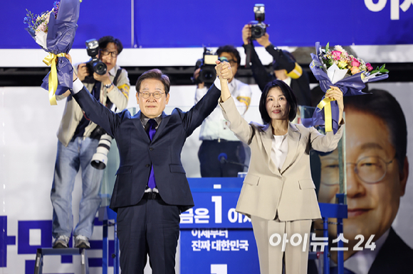 당선이 확실시된 이재명 더불어민주당 대통령 후보와 김혜경 여사가 4일 오전 서울 여의도 국회 앞에서 열린 국민 개표방송 행사에서 꽃다발을 받은 뒤 시민들을 향해 인사하고 있다. [사진=곽영래 기자]