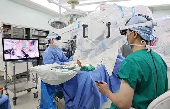 서울아산병원 성형외과 권진근 교수(오른쪽)가 초미세수술 로봇을 이용해 하지 림프부종 환자에게 0.4mm 정도의 가느다란 림프관을 정맥에 연결하는 림프정맥간 문합술을 시행하고 있다. [사진=서울아산병원]