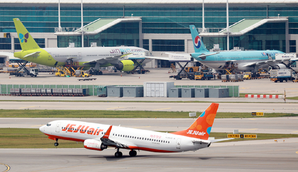 아시아나항공의 인천공항 제2터미널 이전 이후 첫 주말인 17일, 출국객들이 체크인 카운터 인근에서 안내 전광판을 확인하고 있다. [사진=권서아 기자]