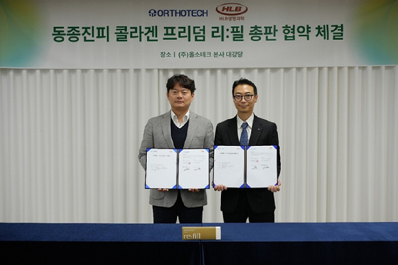 조용호 HLB생명과학 메디케어사업부 사장(사진 오른쪽)과 김일환 올소테크 대표이사가 콜라겐 기반 인체조직 이식재 '프리덤 인젝트 리필' 국내 총판 계약을 체결한 후 기념촬영을 하고 있다. [사진=HLB생명과학 제공]