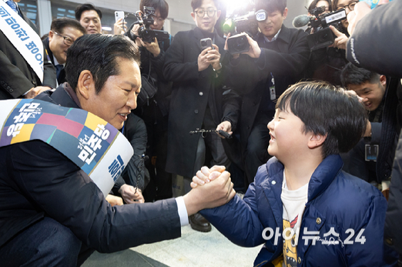 정청래 더불어민주당 대표가 13일 서울 용산역에서 설 귀성객 인사를 하며 아이와 인사를 하고 있다. [사진=곽영래 기자]