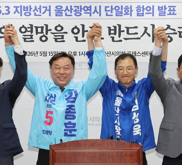 15일 울산시의회 프레스센터에서 더불어민주당 울산시당과 진보당 울산시당이 6&middot;3 지방선거 울산시장 후보 단일화 합의를 발표한 후 진보당 김종훈 후보, 더불어민주당 김상욱 후보가 손을 잡고 인사하고 있다. [사진=연합뉴스]
