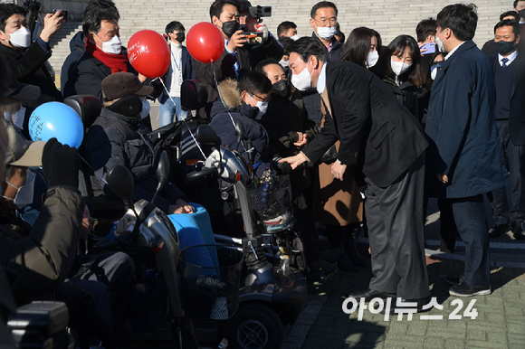 윤석열 국민의힘 대선 후보가 13일 오전 서울 여의도 국회에서 열린 중앙선대위 장애인본부 전국 릴레이정책투어 '장문현답(장애인 문제의 답은 현장에 있다)' 출정식에서 참석자들과 인사하고 있다. [사진=국회사진취재단]