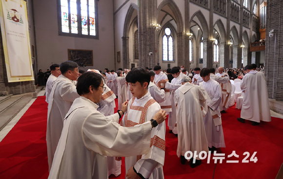 2024년 천주교 서울대교구 부제 서품식이 열린 1일 서울 중구 명동대성당에서 추천 사제들이 부제 수품자들에게 달마티카(부제복)를 입혀주고 있다. [사진=사진공동취재단]