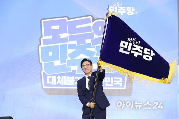 김민석 더불어민주당 신임 당 대표가 17일 대전 컨벤션센터에서 열린 제3회 더불어민주당 정기 전국당원대회에서 당 대표로 선출된 뒤 당기를 흔들고 있다. [사진=곽영래 기자]
