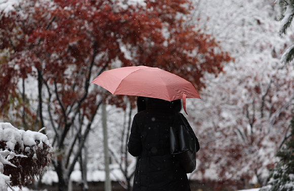 27일 오전 서울 중구 덕수궁 인근에서 한 시민이 이동하고 있다. [사진=연합뉴스]