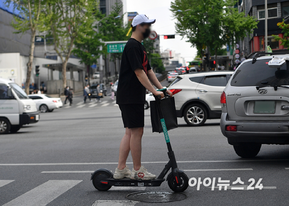 전동킥보드로 횡단보도를 건너고 있다. [사진=아이뉴스DB]