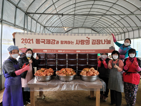 신당꿈 구립지역아동센터 교사와 학부모들이 동국제강이 전달한 김장 재료를 활용해 김장을 담그고 있는 모습. [사진=동국제강]